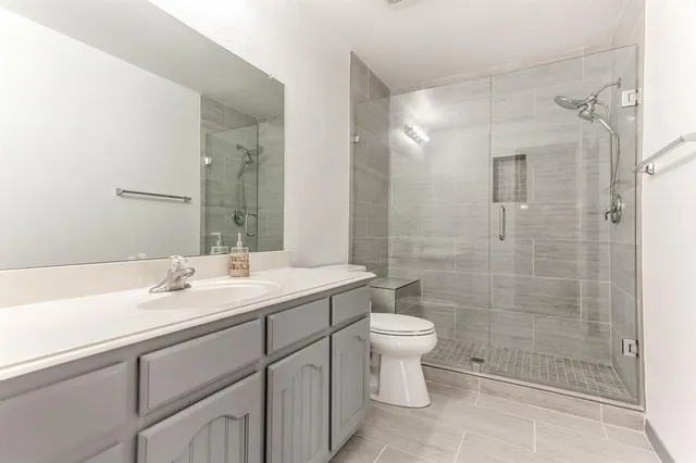 a bathroom with a sink a toilet and shower