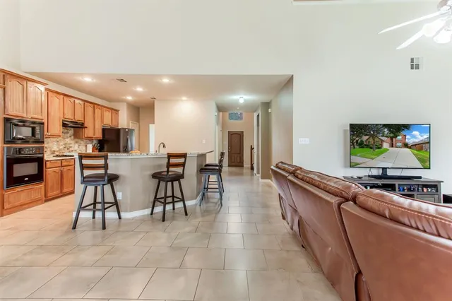 a dining hall with stainless steel appliances a dining table and chairs