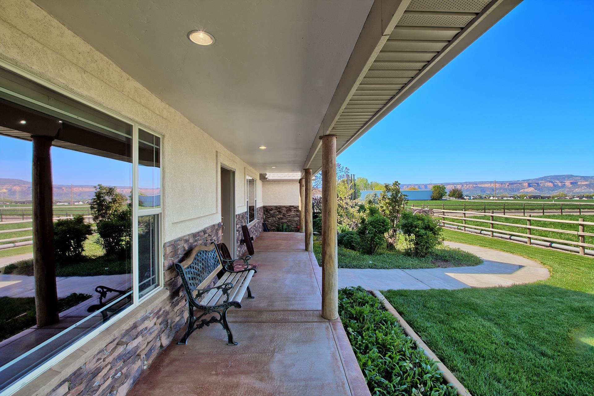 2302 Outback Ridge Road Grand Junction, CO 81505 - Photo 6 of 42 a view of a patio with table and chairs potted plants with wooden floor and fence