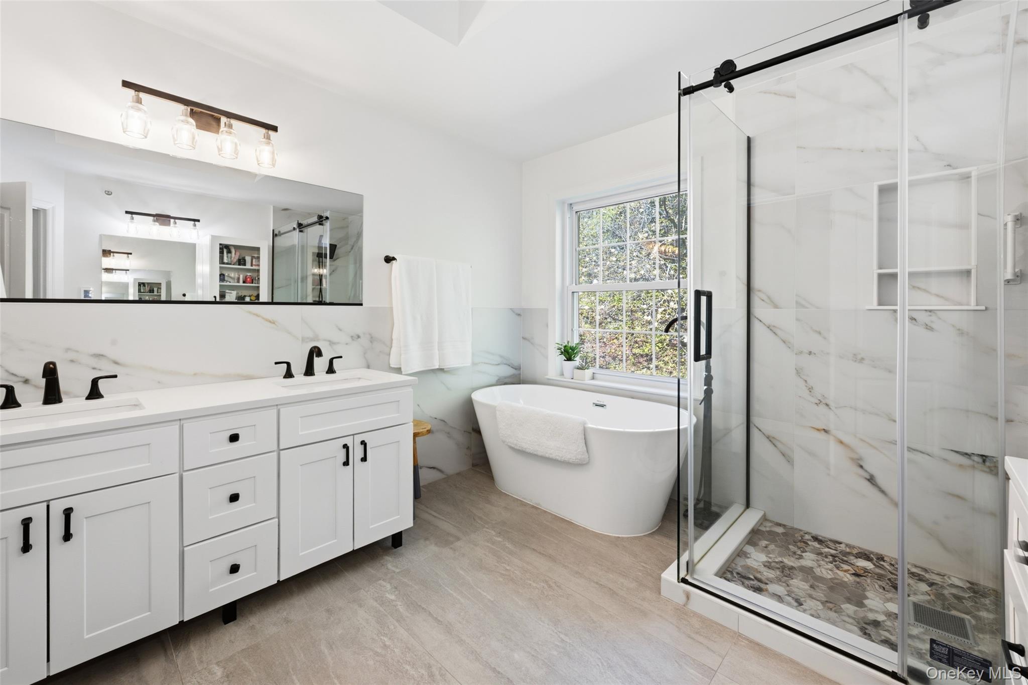 40 Bellefair Road Rye Brook, NY 10573 - Photo 23 of 43 Luxurious Primary en- suite bath equipped with a soaking tub and glass enclosed shower - double vanities and toilet room