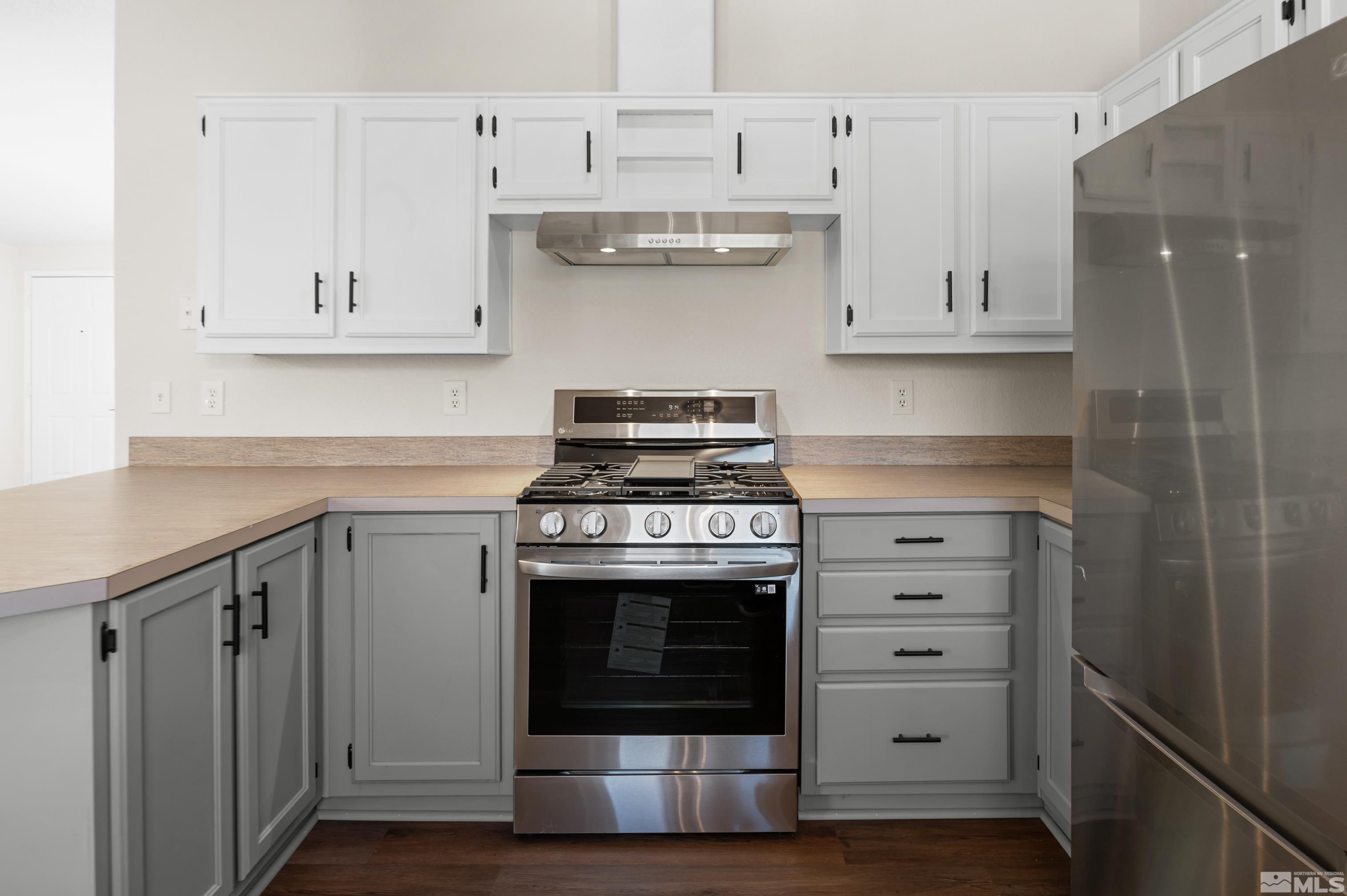 10 Rodeo Drive Reno, NV 89508 - Photo 11 of 37 a kitchen with stainless steel appliances granite countertop a stove and a refrigerator with white cabinets