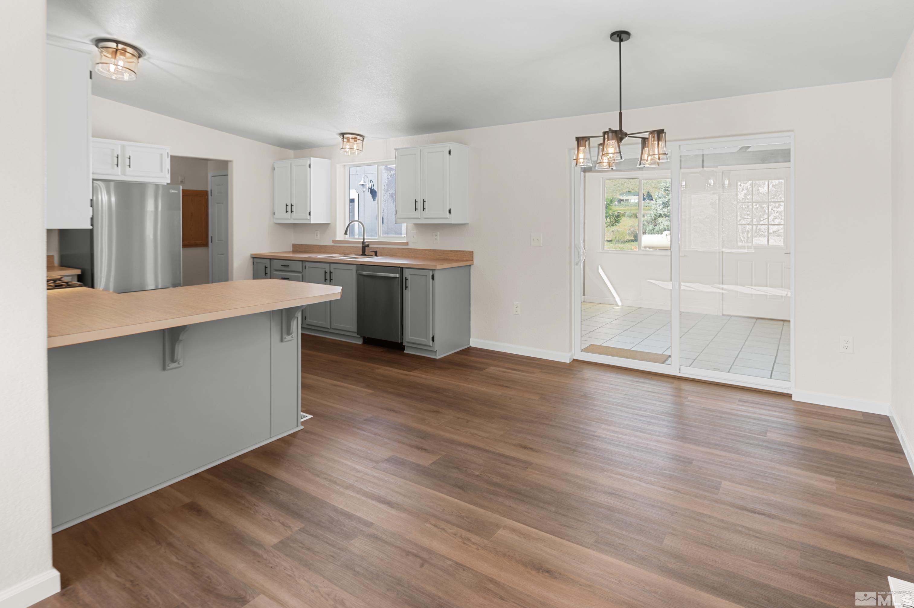 10 Rodeo Drive Reno, NV 89508 - Photo 9 of 37 a view of a kitchen with stainless steel appliances granite countertop a sink dishwasher a refrigerator and wooden floor