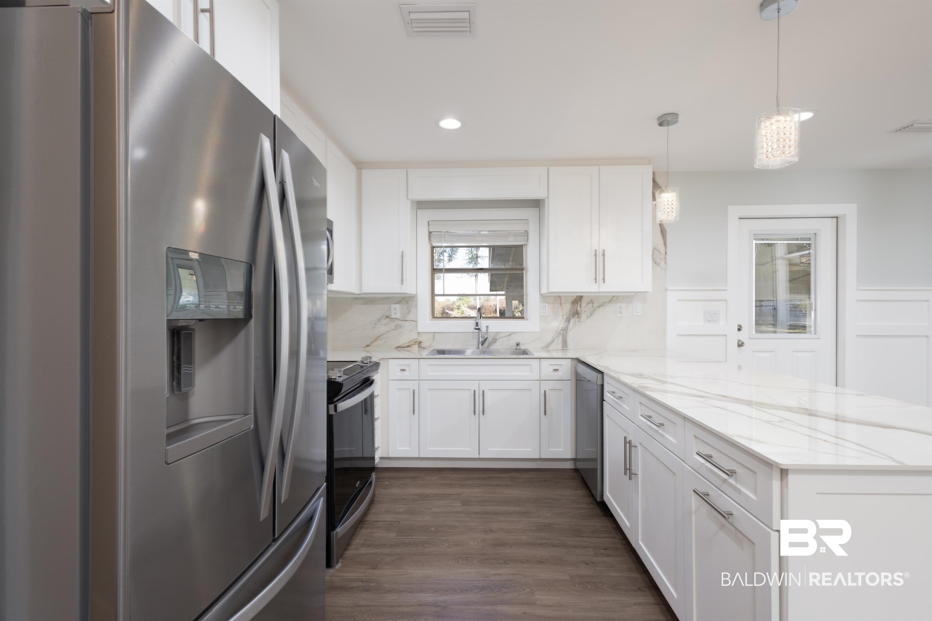 18267 Highway 98 Foley, AL 36535 - Photo 6 of 26 Kitchen featuring stainless steel appliances, a peninsula, pendant lighting, white cabinets, and light stone countertops