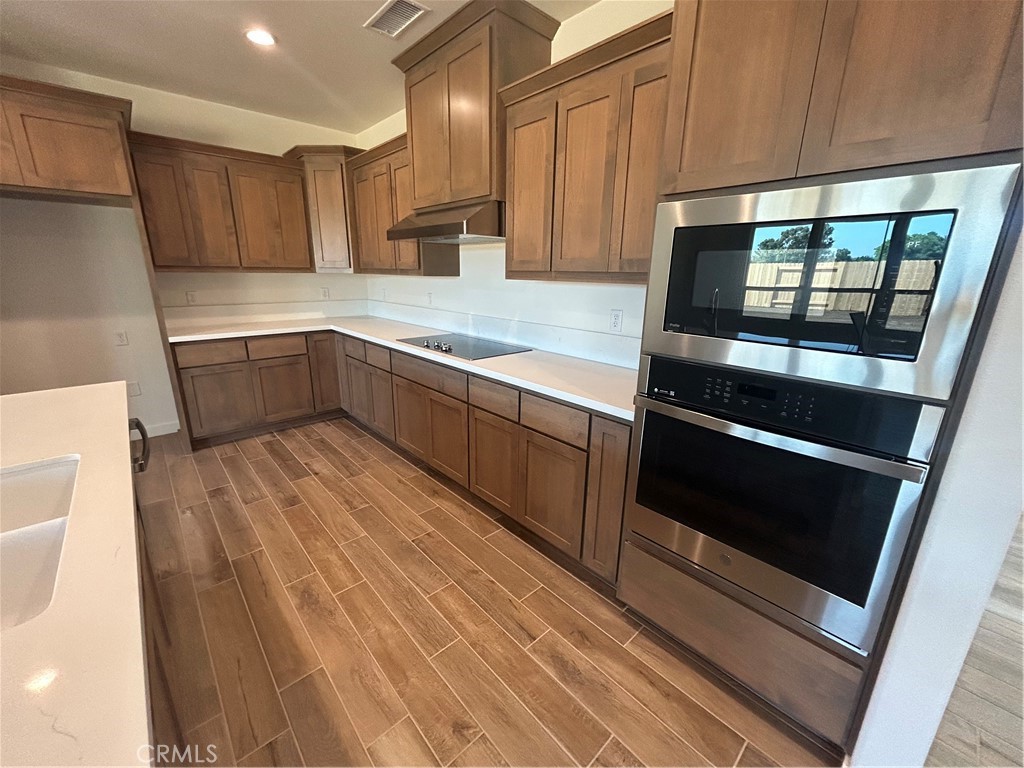 325 Bainbridge Place Chico, CA 95973 - Photo 13 of 26 a kitchen with wooden floors and stainless steel appliances
