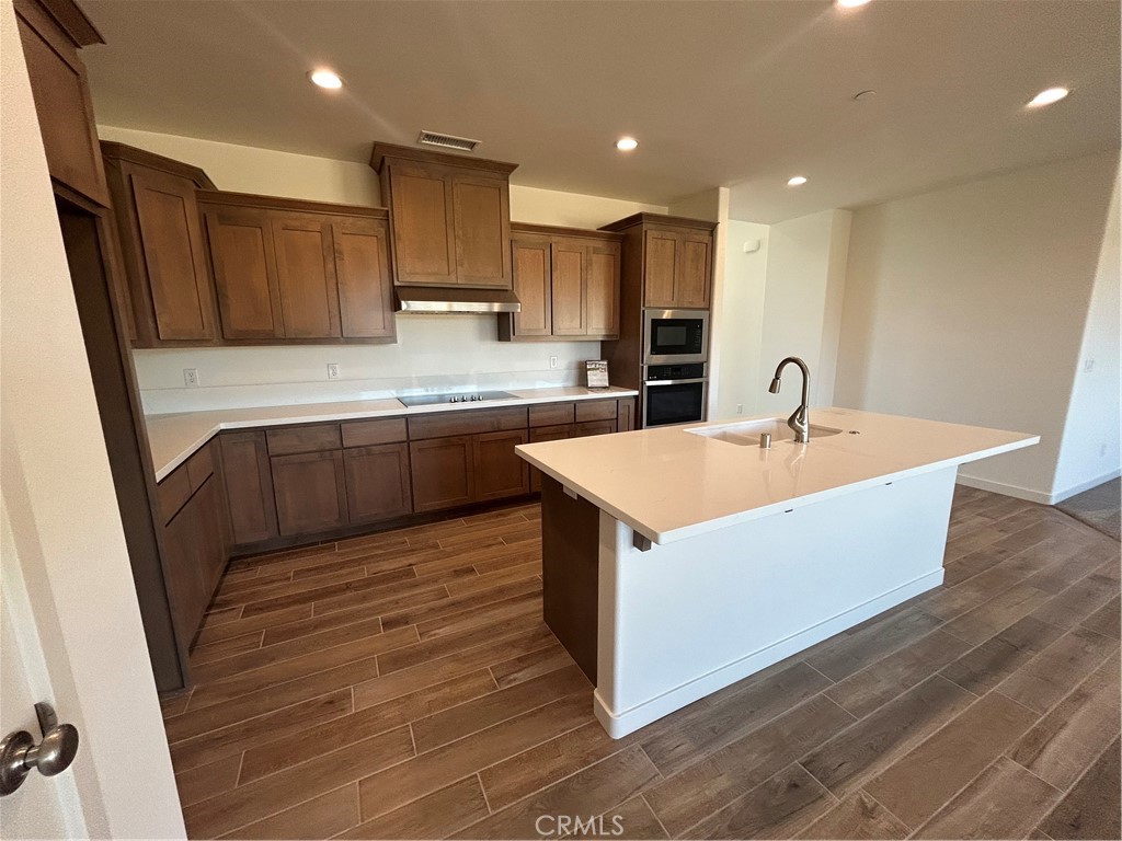 325 Bainbridge Place Chico, CA 95973 - Photo 16 of 26 a large kitchen with kitchen island a sink a stove a refrigerator and a cabinets with wooden floor
