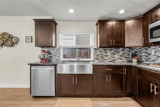 a kitchen with stainless steel appliances granite countertop a sink and a stove