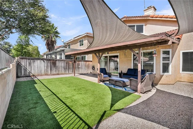 a view of a chair and table in backyard of the house