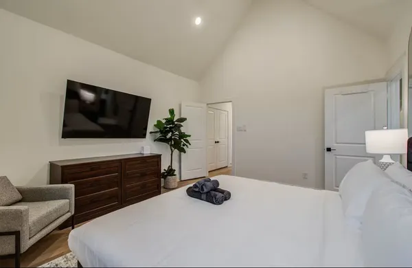 a bedroom with a bed and a flat screen tv