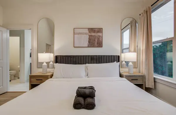 a bedroom with a bed and a large mirror
