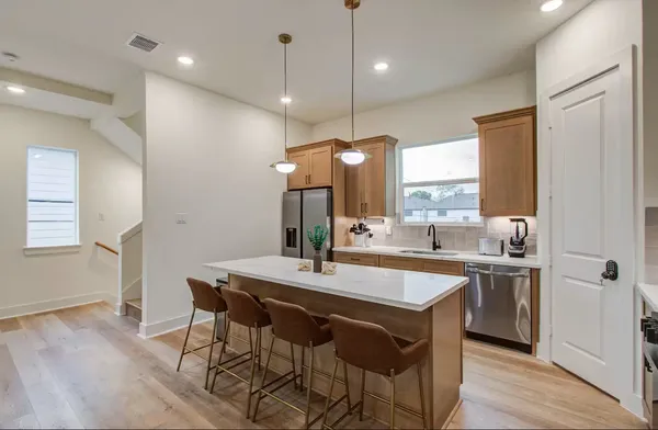a kitchen with a table chairs sink and wooden floor