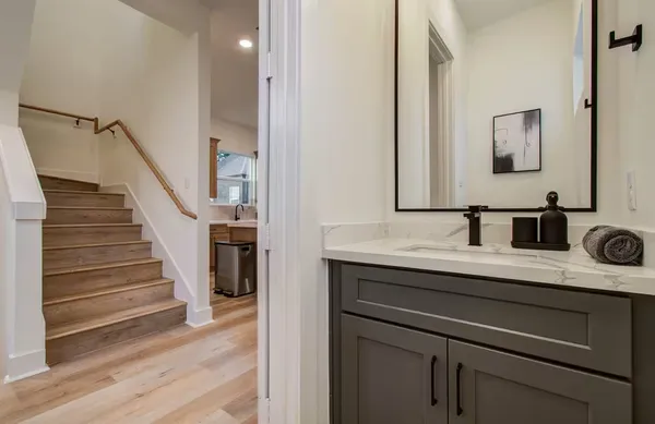 a en suite bathroom with a granite countertop sink and a mirror