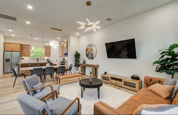 a living room with furniture a flat screen tv and kitchen view