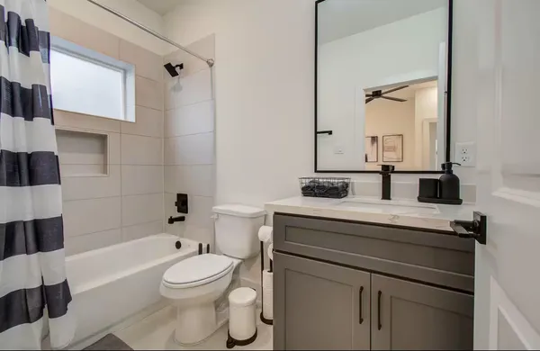 a bathroom with a sink a toilet a mirror and shower