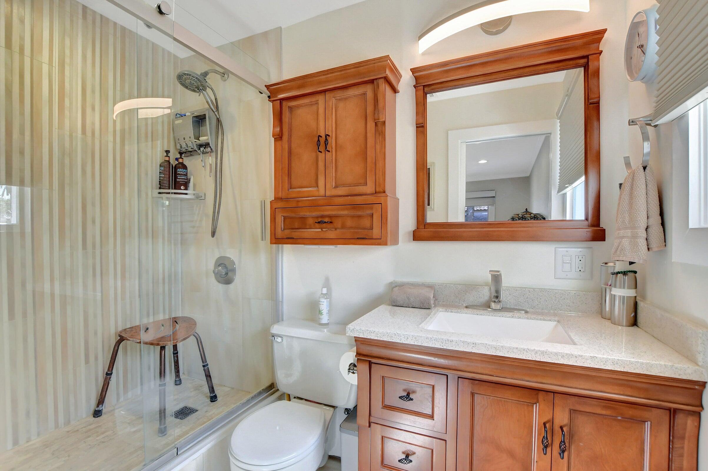 1599 Isabel Este Road Boca Raton, FL 33486 - Photo 12 of 22 a bathroom with a sink a toilet and mirror