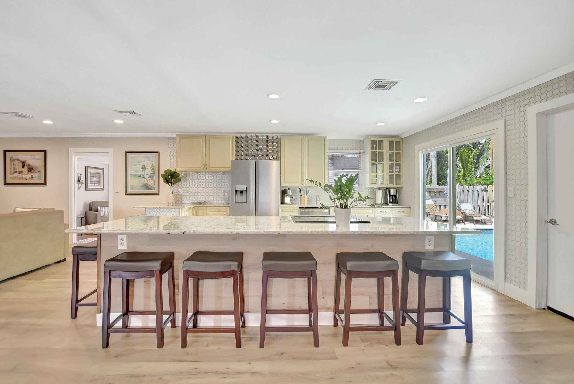 1599 Isabel Este Road Boca Raton, FL 33486 - Photo 3 of 22 a kitchen with granite countertop a table and chairs in it
