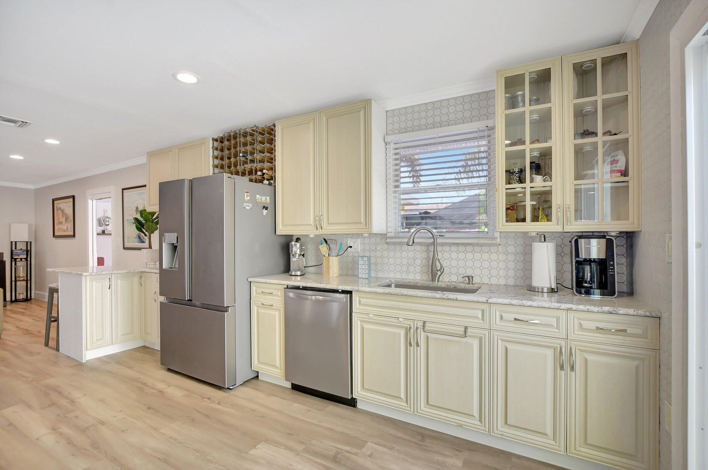 1599 Isabel Este Road Boca Raton, FL 33486 - Photo 5 of 22 a kitchen with stainless steel appliances a refrigerator sink and cabinets