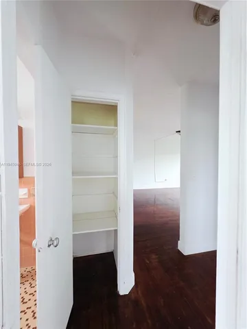a view of walk in closet with empty racks