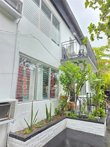 a house with a flower garden and potted plants