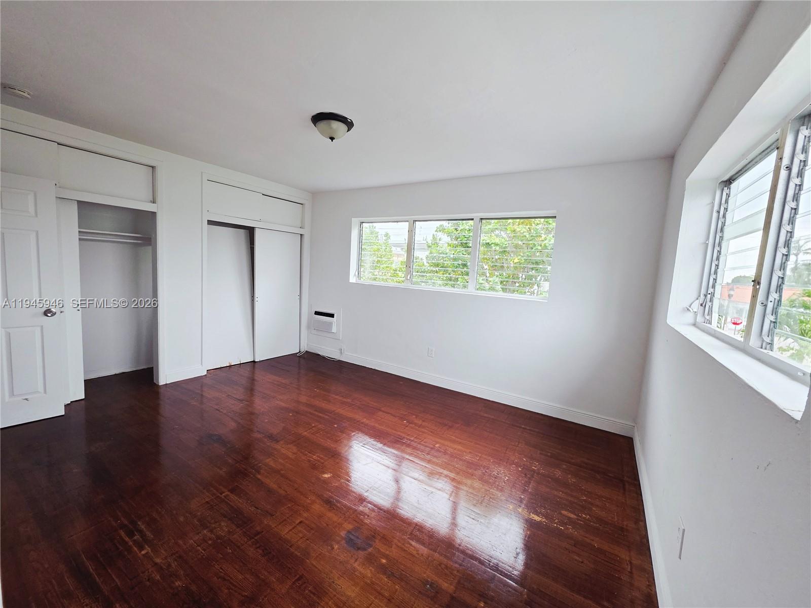 824 82nd Street, Unit 4 Miami Beach, FL 33141 - Photo 8 of 13 an empty room with wooden floor and windows