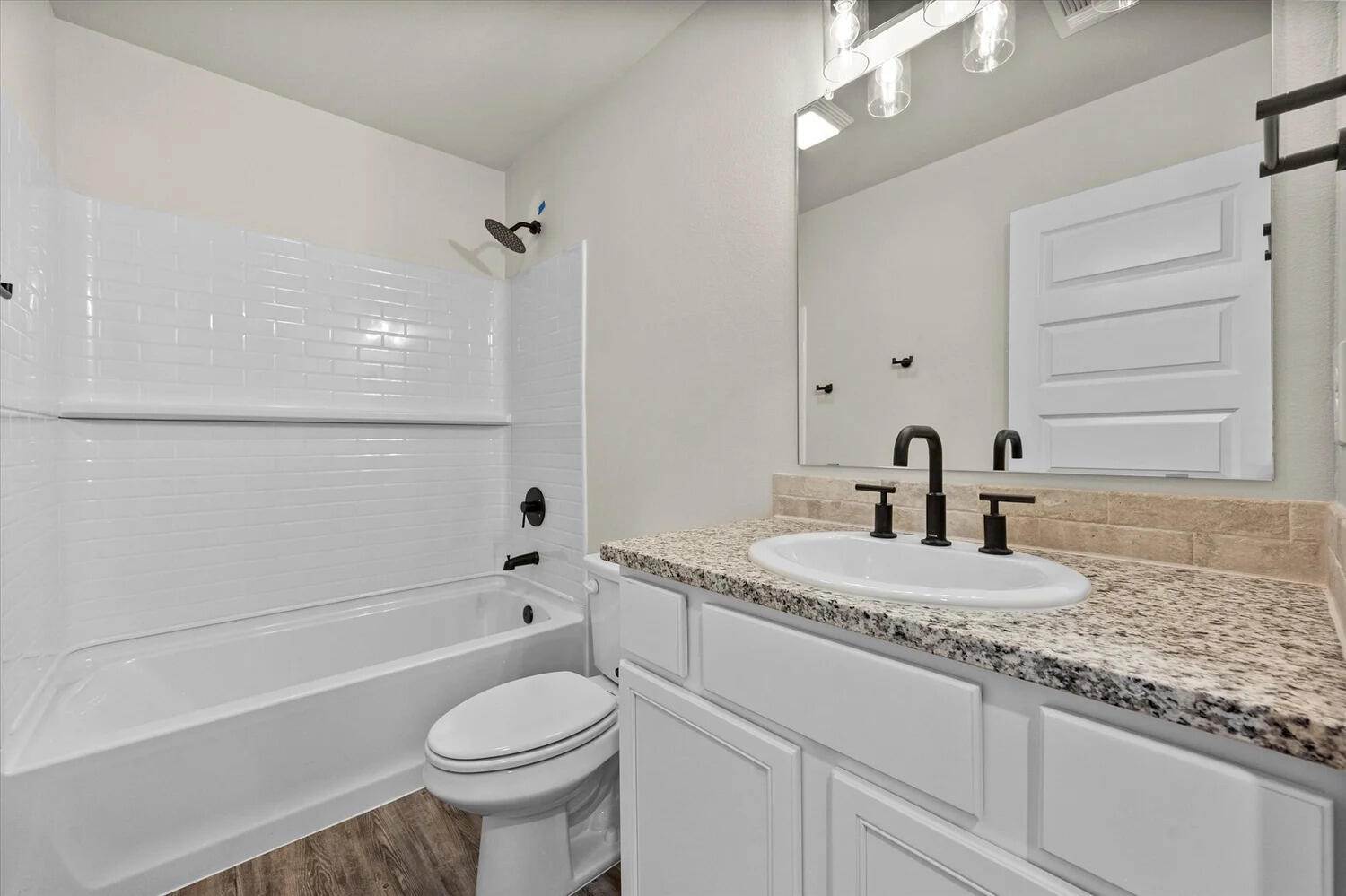 7446 29th Street Lubbock, TX 79407 - Photo 10 of 11 a bathroom with a granite countertop toilet sink and mirror