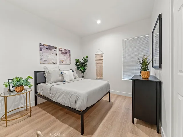 a bedroom with a bed and a potted plant