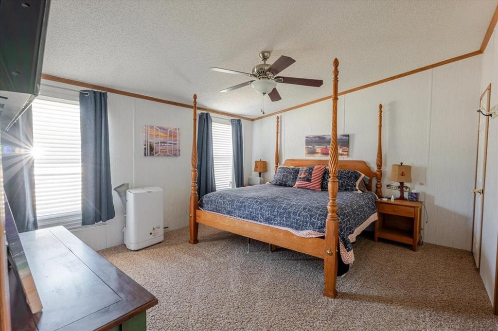 4441 Chapel Road Graham, TX 76450 - Photo 13 of 39 a bedroom with a bed and a chandelier