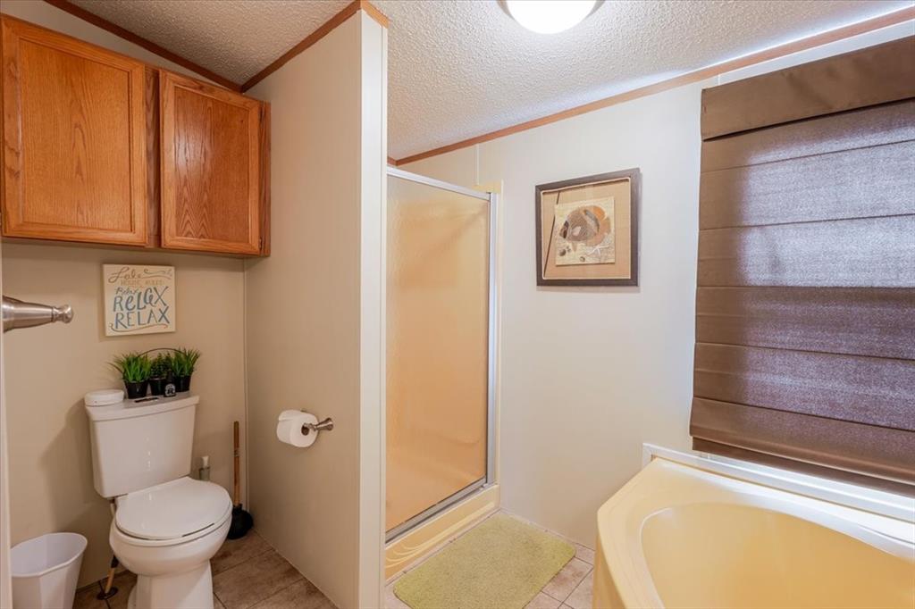 4441 Chapel Road Graham, TX 76450 - Photo 15 of 39 a bathroom with a toilet and a shower