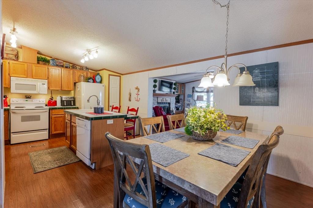 4441 Chapel Road Graham, TX 76450 - Photo 24 of 39 a kitchen with stainless steel appliances a dining table chairs and wooden floor