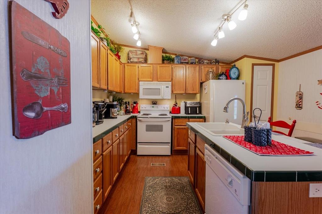 4441 Chapel Road Graham, TX 76450 - Photo 25 of 39 a kitchen with kitchen island granite countertop a sink appliances cabinets and a counter top space