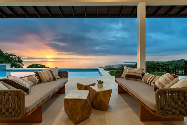 a roof deck with couches and potted plants