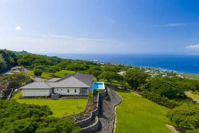 an aerial view of a house having swimming pool a yard and lake view