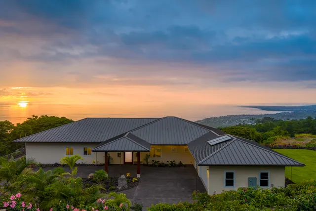 an aerial view of a house with a yard and balcony