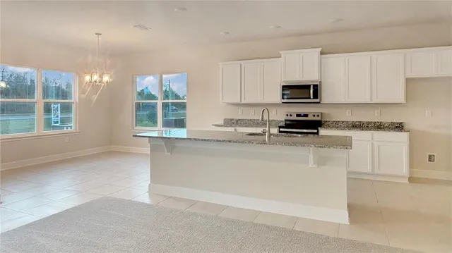 a kitchen with stainless steel appliances granite countertop white cabinets and window