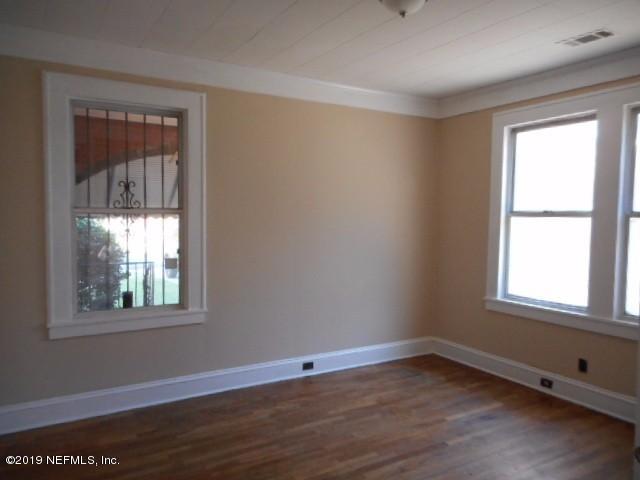 3359 Norman Bridge Road Montgomery, AL 36105 - Photo 2 of 10 an empty room with wooden floor and windows