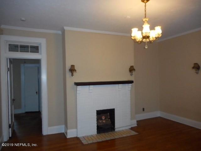 3359 Norman Bridge Road Montgomery, AL 36105 - Photo 3 of 10 a living room with a fireplace furniture a rug and a chandelier