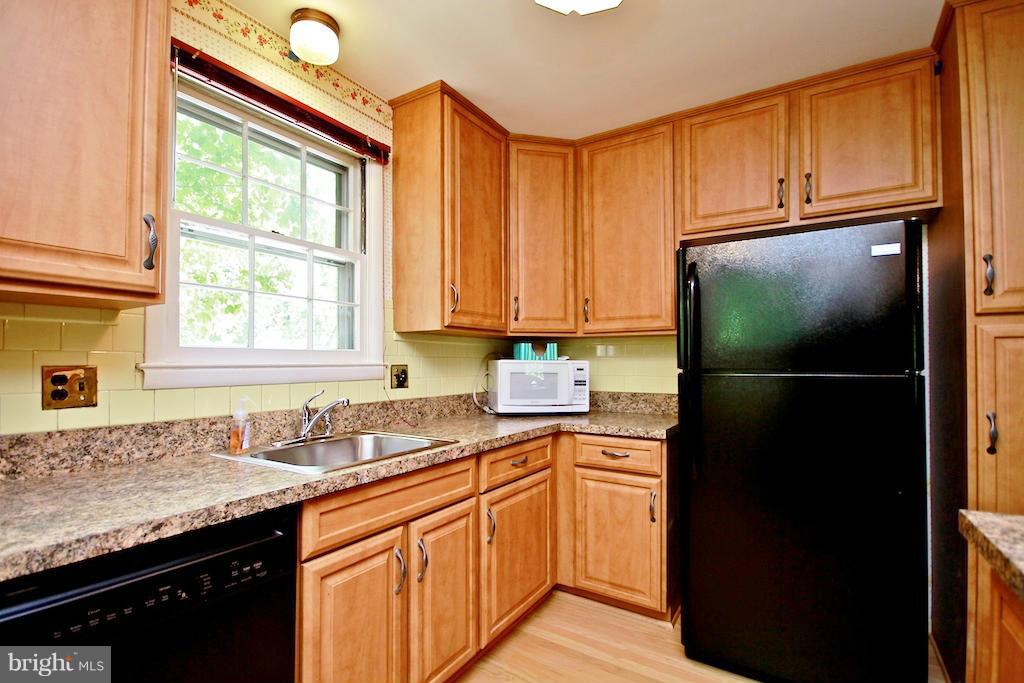8200 Burnley Road Baltimore, MD 21204 - Photo 3 of 21 a kitchen with a sink a refrigerator and cabinets