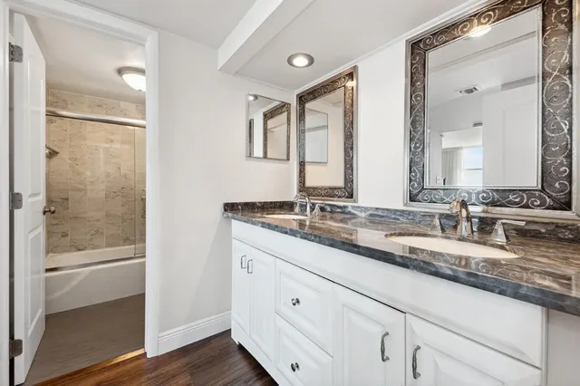 a bathroom with double vanity sink and a mirror