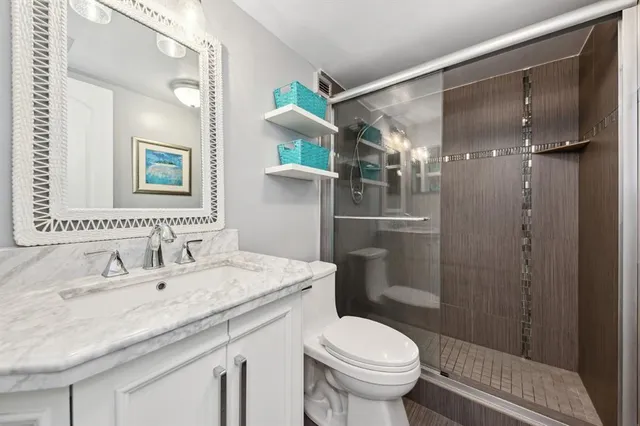 a bathroom with a granite countertop sink toilet and shower