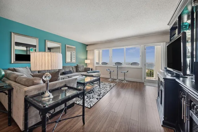 a living room with furniture a flat screen tv and a wooden floor