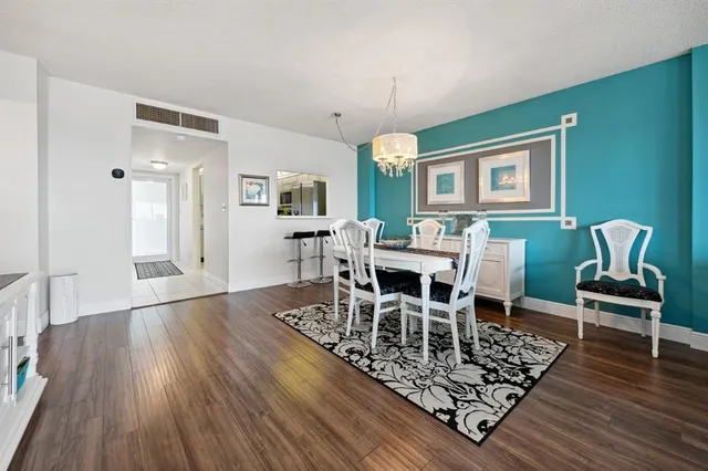a dining room with furniture a chandelier and wooden floor