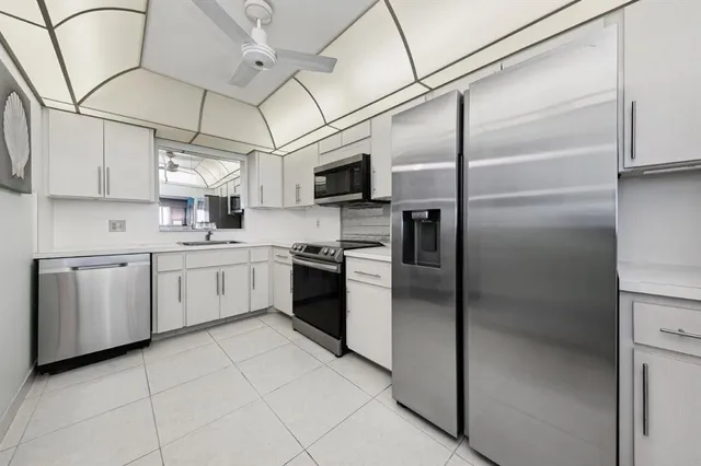 a kitchen with a refrigerator sink and cabinets