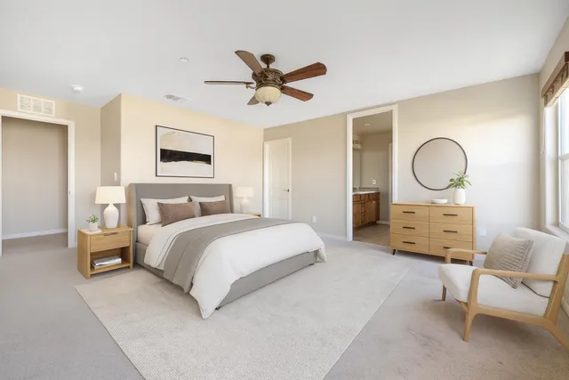 a spacious bedroom with a bed a window and a chandelier