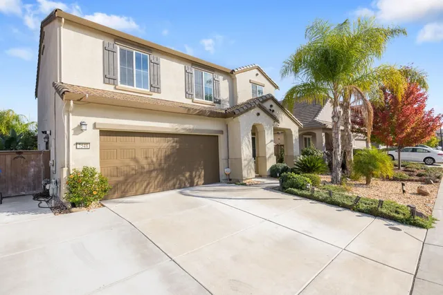 a front view of a house with a yard and potted plants
