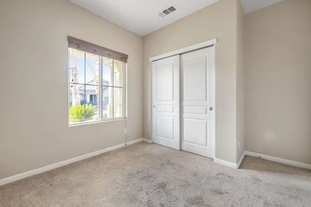 an empty room with windows and closet
