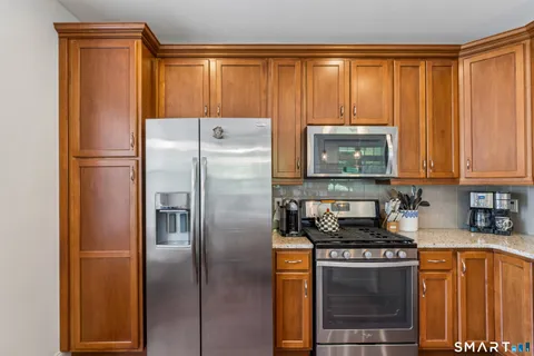 a kitchen with stainless steel appliances granite countertop a refrigerator and a sink