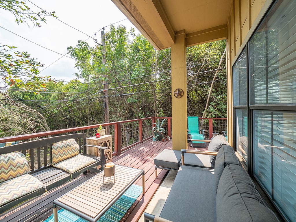 3609 Clawson Road, Unit B Austin, TX 78704 - Photo 16 of 28 Spacious outdoor deck featuring rich wood-finish flooring, a sturdy wood railing with metal infill, and a private, tree-lined perimeter