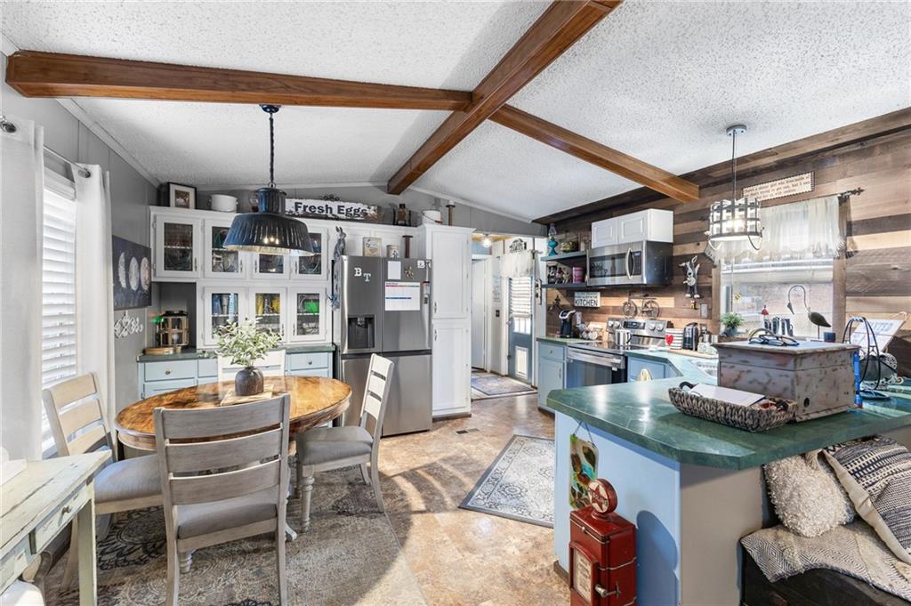224 Hebron Road Commerce, GA 30530 - Photo 6 of 25 a kitchen with stainless steel appliances granite countertop a table chairs and a refrigerator