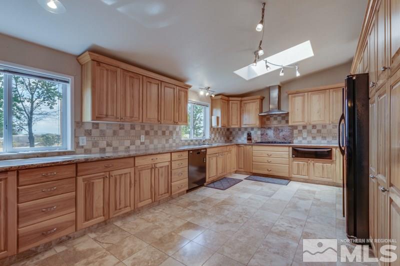 4989 Cody Road Fallon, NV 89406 - Photo 6 of 39 a large kitchen with granite countertop a large counter top space a sink stainless steel appliances and cabinets