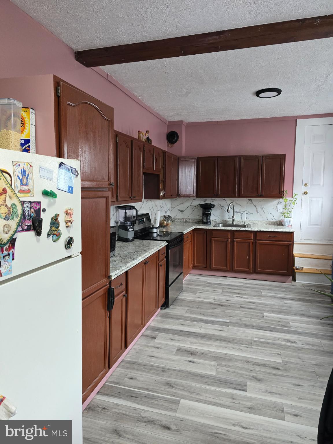 1237 Cotton Street Reading, PA 19602 - Photo 6 of 11 a kitchen with stainless steel appliances granite countertop a refrigerator sink and wooden cabinets