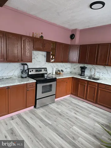 a kitchen with stainless steel appliances granite countertop a sink stove and cabinets
